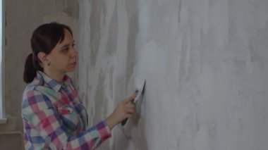 Bir kadın evinde tamirat yaparken duvara macun yapıştırıyor. Çalışma süreci, kadın işçi macun çözeltisi koyuyor. Kendi ellerinle onar. Metin için yer