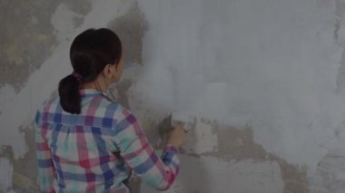 Bir kadın evinde tamirat yaparken duvara macun yapıştırıyor. Çalışma süreci, kadın işçi macun çözeltisi koyuyor. Kendi ellerinle onar. Metin için yer