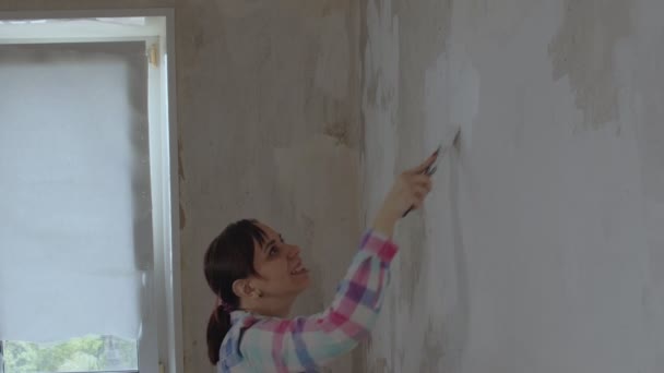 Widok Boku Młodej Kobiety Nakładającej Kit Ścianę Pokoju Pracownica Tynkująca — Wideo stockowe
