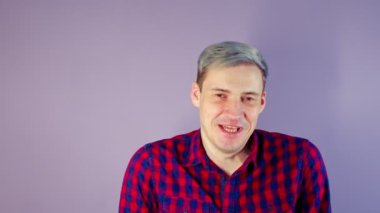 Mor arka planda tokat yiyen genç adama yakın çekim. Tanınmayan bir kadın, arsız adamın yanağına hak ettiği şekilde vurur..