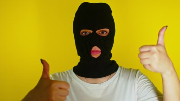 Close Unrecognizable Woman Black Balaclava Showing Thumbs Yellow Background Unknown — Stock Video