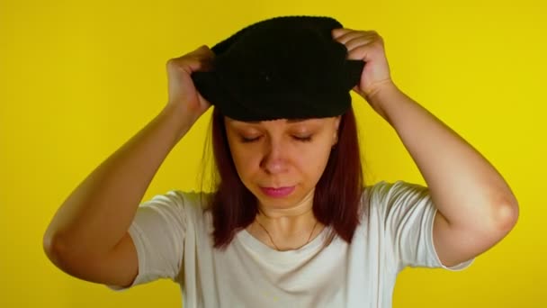 Close Young Woman Puts Black Balaclava Yellow Background Secretive Female — Stock Video