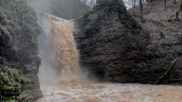 Vackert landskap med mäktigt lerigt vattenfall i bergig terräng. Smutsiga vattendrag i bergen rinner ner och stänk. — Stockvideo