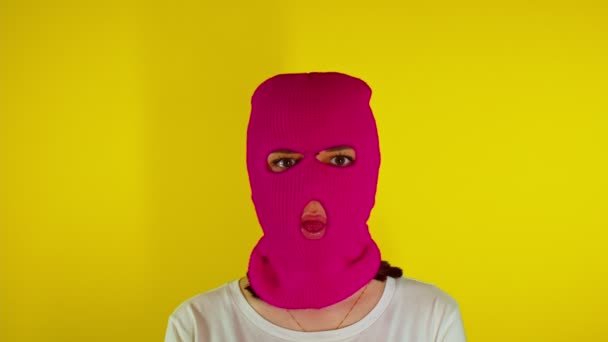 Close Mulher Irreconhecível Balaclava Rosa Mostra Sua Língua Fundo Amarelo — Vídeo de Stock