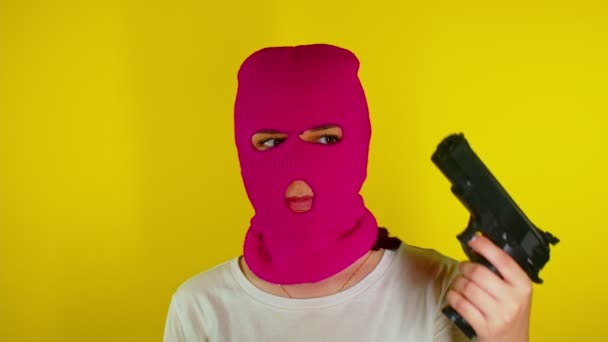 Крупный План Неузнаваемой Женщины Розовой Балаклаве Пистолетом Желтом Фоне Неизвестная — стоковое видео