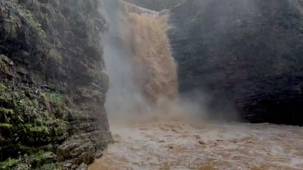 Bellissimo paesaggio di potente cascata fangosa in terreno montagnoso. Sporco corso d'acqua di montagna scorre verso il basso e spruzzi. — Video Stock