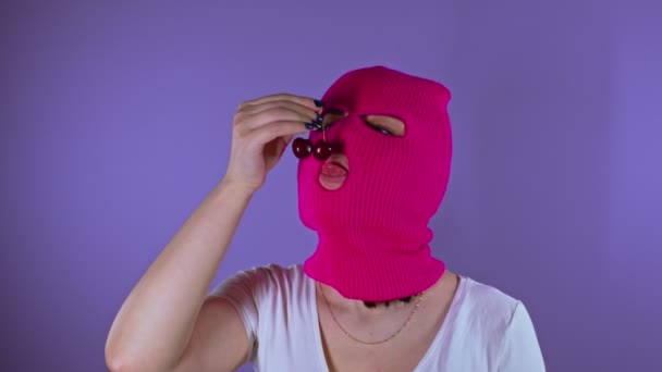 Zbliżenie Młodej Kobiety Różowej Kominiarce Zjada Słodką Wiśnię Fioletowym Tle — Wideo stockowe