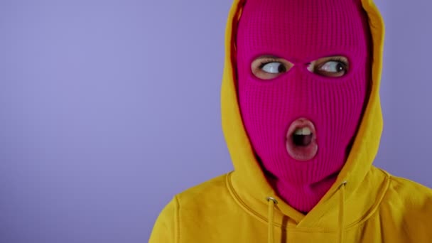 Close Young Woman Pink Balaclava Yellow Hood Grimacing Face Purple — Stock Video