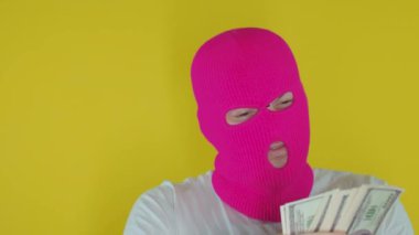 Sarı arka planda, pembe kar maskeli bir adama yaklaş. Meçhul adam çok para kazanıyor. Hırsızlık ve soygun kavramı