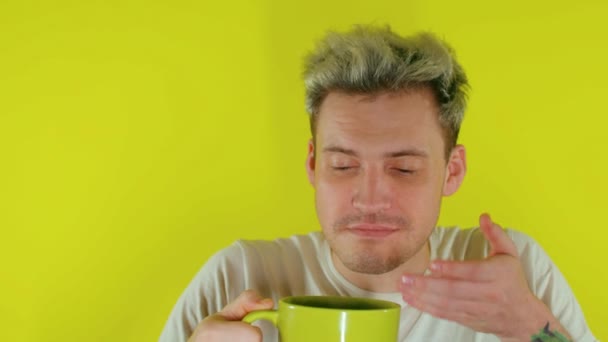 Sarı Arka Planda Büyük Bir Fincan Kahveyle Uykulu Adama Yaklaş — Stok video