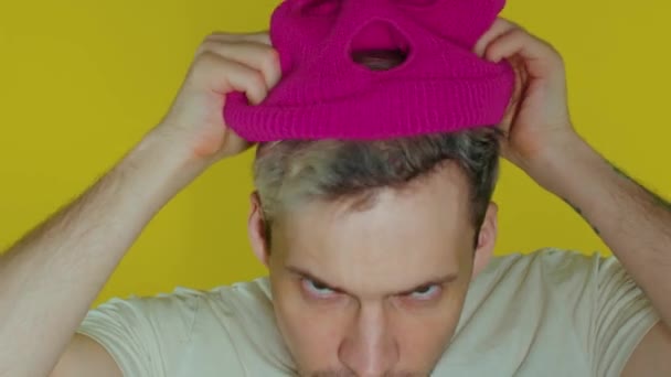 Close Man Puts Pink Balaclava Yellow Background Secretive Guy Puts — Stock Video