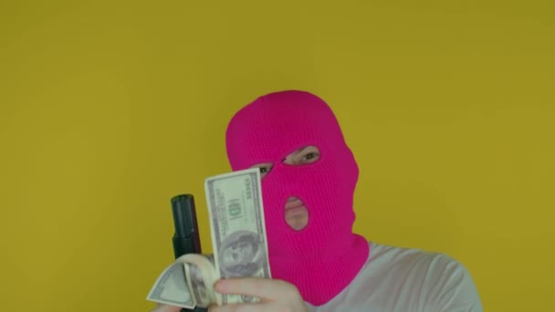 Κοντινό Πλάνο Του Ανθρώπου Ροζ Μπαλακλάβα Χρήματα Και Όπλο Κίτρινο — Αρχείο Βίντεο