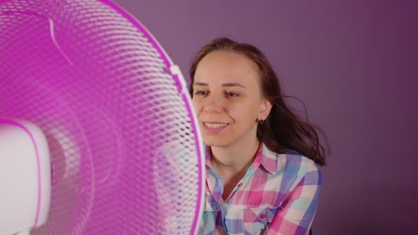 Крупним Планом Молода Жінка Сидить Стільці Перед Вентилятором Фіолетовому Фоні — стокове відео