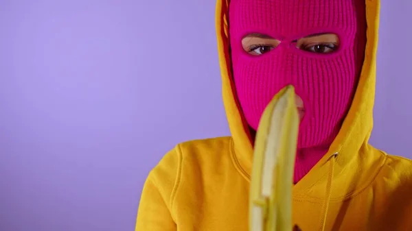 Közelkép Fiatal Rózsaszín Maszk Sárga Motorháztető Peeling Banán Lila Háttér — Stock Fotó