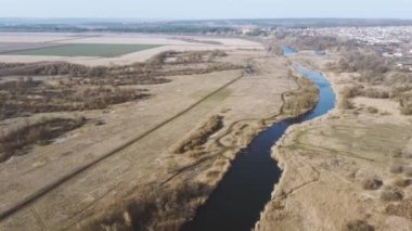 Kırsal kesimde sakin bir nehir. Yukarıdan, doğadaki bir bahar ormanının yanında sakin suyu olan inanılmaz bir nehir. Ağaçların arasından akan dar, dolambaçlı bir nehir..