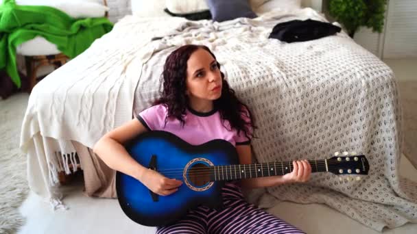 Yatak Odasında Gitar Çalan Genç Bir Kadın Yatağının Yanında Gitar — Stok video