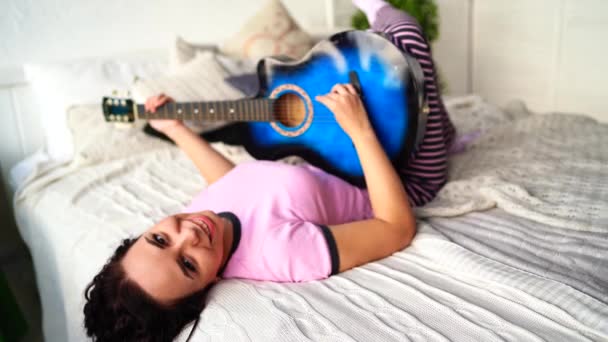 Yatak Odasında Gitar Çalan Genç Bir Kadın Yatağında Gitar Çalan — Stok video