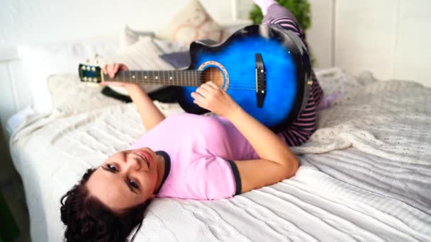 Yatak Odasında Gitar Çalan Genç Bir Kadın Yatağında Gitar Çalan — Stok video