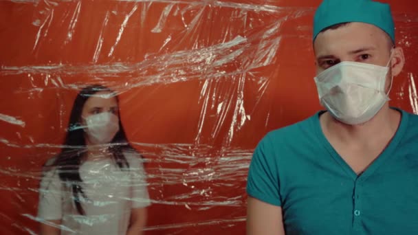 戴口罩的年轻女子被迫与结肠炎病毒隔离戴口罩的男医生将他的病人与病毒传播相隔离 感染威胁的概念 — 图库视频影像