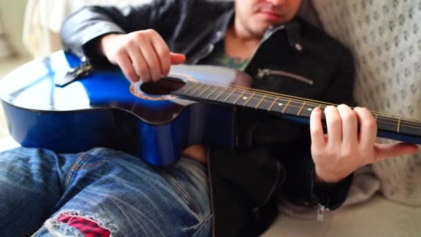 Een Jongeman Met Een Tatoeage Zijn Borst Speelt Gitaar Slaapkamer — Stockvideo