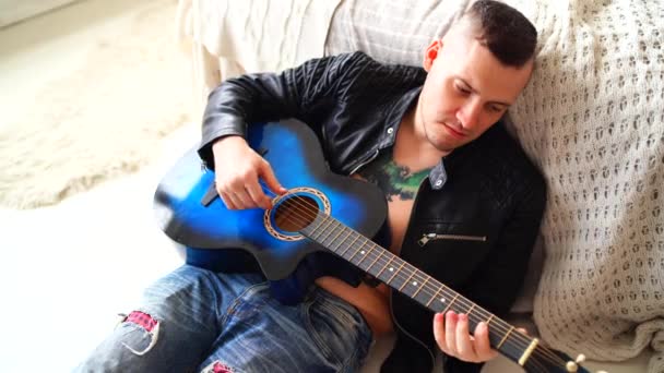 Ένας Νεαρός Τατουάζ Στο Στήθος Παίζει Κιθάρα Στην Κρεβατοκάμαρα Χίπστερ — Αρχείο Βίντεο