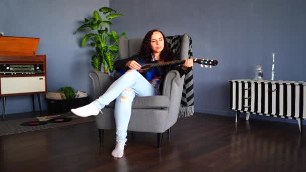 Gündelik Giysiler Içinde Genç Güzel Bir Kadın Koltuğunda Oturup Gitar — Stok video