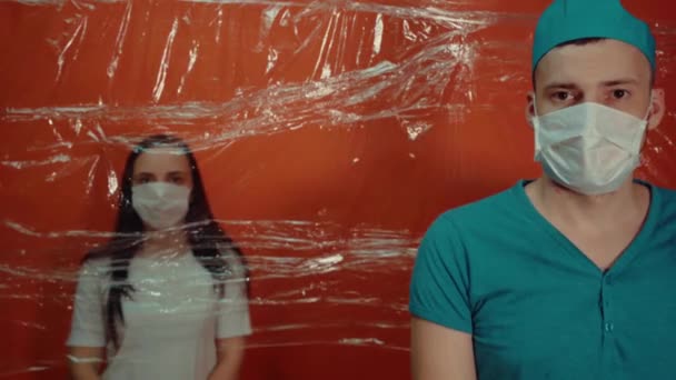 戴口罩的年轻女子被迫与结肠炎病毒隔离戴口罩的男医生将他的病人与病毒传播相隔离 感染威胁的概念 — 图库视频影像