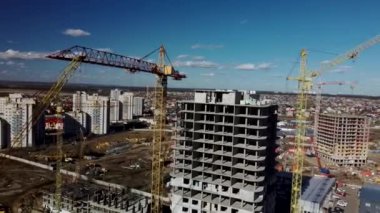 Vinçli inşaat alanı. Arkaplanda gökyüzü olan ağır makineli inşaat alanı