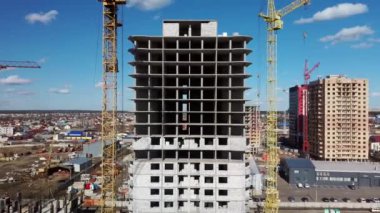 Vinçli inşaat alanı. Arkaplanda gökyüzü olan ağır makineli inşaat alanı