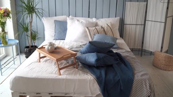 有枕头和毛毯的大床 伍登站在工作室皱巴巴的床上吃早餐 室内设计室的特写 — 图库视频影像