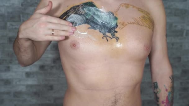 Egy Férfi Krémet Keneget Hiányos Tetoválásra Mellkasán Közelkép Férfi Kézről — Stock videók