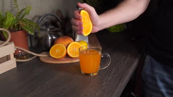 一名男子在厨房挤压橙子 以获得新鲜榨橙汁 特写镜头 — 图库视频影像
