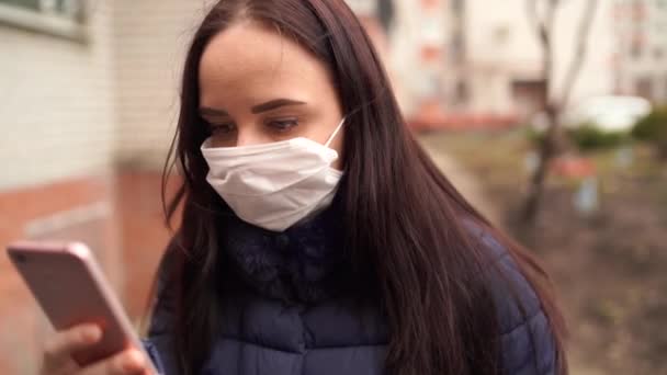 Yüzünde Tıp Maskesi Olan Genç Bir Kadın Sokaklarda Cep Telefonundan — Stok video