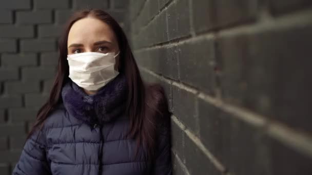 Potret Wanita Muda Bertopeng Medis Wajahnya Terhadap Dinding Bata Hitam — Stok Video