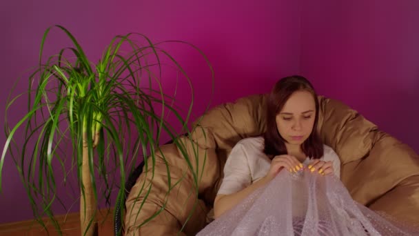 Young Woman Plays Bubble Wrap Sitting Armchair Room Brunette Hugs — Stock Video