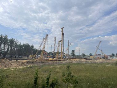 İnşaat devam ediyor ve yaz mevsiminde inşaat alanında ağır makineler var. Kırsal kesimde inşaat ekipmanlarıyla birlikte iş projesi