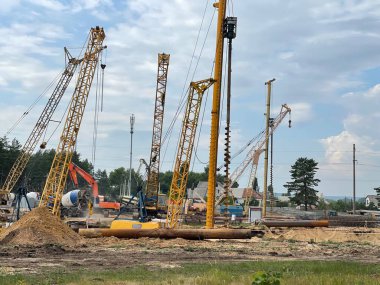 İnşaat devam ediyor ve yaz mevsiminde inşaat alanında ağır makineler var. Kırsal kesimde inşaat ekipmanlarıyla birlikte iş projesi