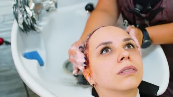 一个女人染完头发后 在美容院里洗头 理发师在沙龙里把一个年轻姑娘打扮成一个发型 — 图库视频影像