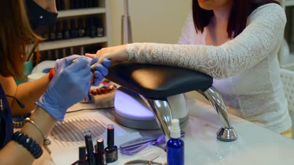 一个女人在美容院里修指甲 美容师大师在给绿色油画客户涂指甲美容业概念 — 图库视频影像
