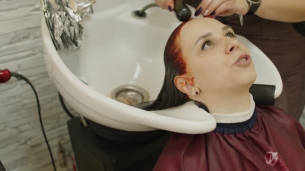 Jonge Vrouw Zit Hoofd Gootsteen Tijdens Haarverzorging Procedure Salon Onherkenbaar — Stockvideo