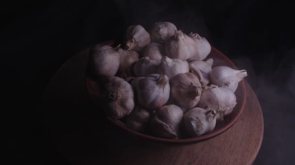 桌上的陶瓷碗里堆满了大蒜 黑色背景的未剥皮蔬菜的收获 — 图库视频影像