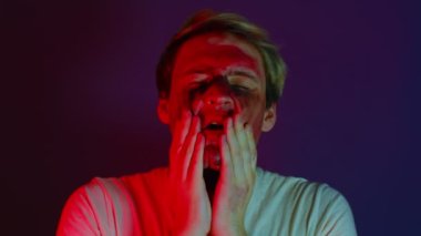 Adam tehdit edici bir şekilde yüzüne boya bulaştırıyor.