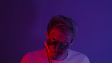 Kızgın adam, manyak ya da deli, karanlık bir odada duran bıçağı yalıyor. Bıçaklı bir portre adamı. Seri katil manyağı..