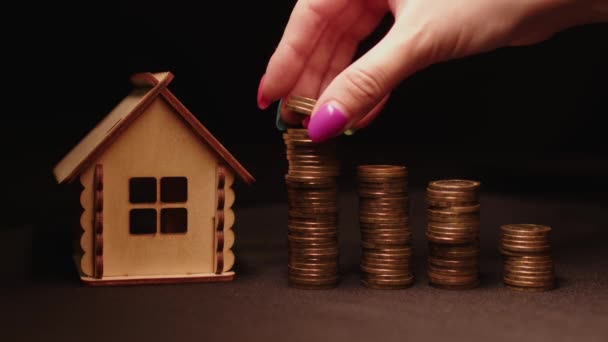 Pequeña Casa Madera Con Columnas Monedas Sobre Fondo Negro Mano — Vídeos de Stock