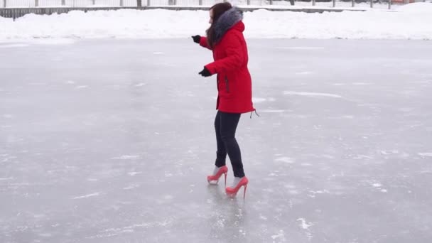 Νεαρή Γυναίκα Χειμωνιάτικα Ρούχα Και Ψηλοτάκουνα Παπούτσια Γλιστράει Στον Πάγο — Αρχείο Βίντεο
