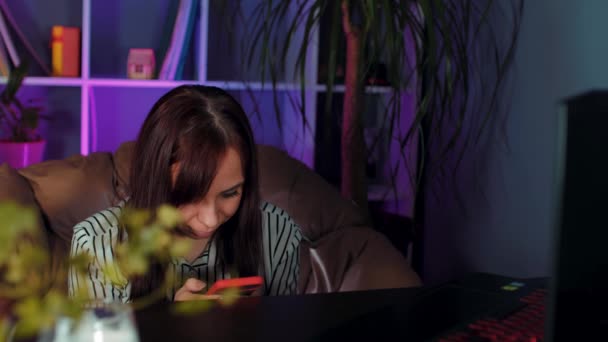 Νεαρή Γυναίκα Που Χρησιμοποιεί Smartphone Κάθεται Στην Πολυθρόνα Πριν Από — Αρχείο Βίντεο