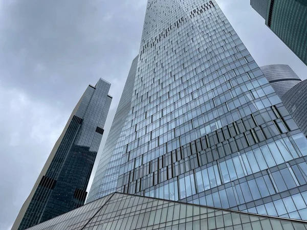 ガラスの壁と現代の超高層ビルのファサード ダウンタウンの曇りの空に対してガラスの壁と現代の高層ビルの下から — ストック写真