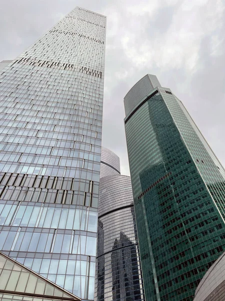 ガラスの壁と現代の超高層ビルのファサード ダウンタウンの曇りの空に対してガラスの壁と現代の高層ビルの下から — ストック写真
