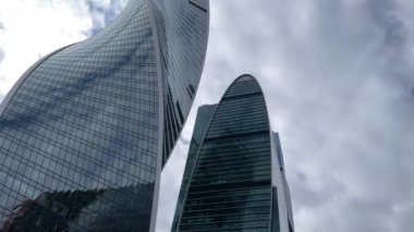 Camdan duvarları olan modern gökdelen cephesi şehir merkezinde bulutlu gökyüzüne karşı cam duvarları olan çağdaş yüksek gökdelenden