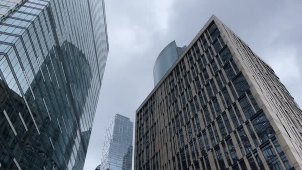 现代玻璃墙摩天大楼的立面在市中心 现代高耸的玻璃墙摩天大楼的下方 与多云的天空相映成趣 — 图库视频影像